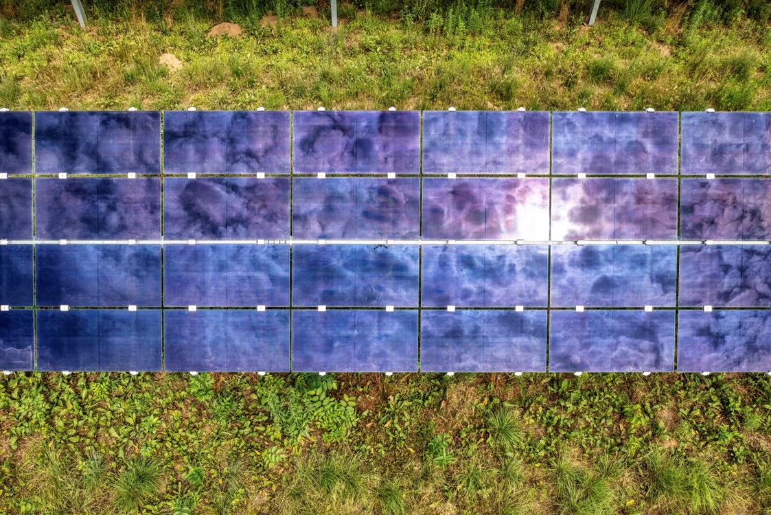 Aerial view of ground-mounted solar panels on open land at a commercial site in Hartford, CT.